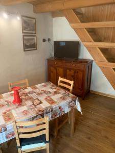 a dining room with a table and a television at Les Chambrettes in Champoluc