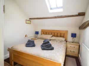 a bedroom with a bed with blue towels on it at Mousehole Cottage in Carlisle