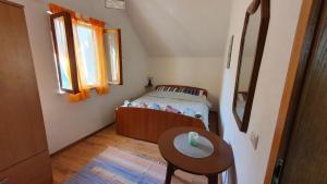 a small bedroom with a bed and a table at Holiday Home Jere in Postira