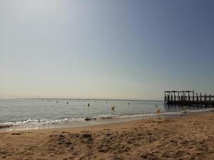 a beach with a pier and people in the water at Maison de village 60m2 pratique et confortable in Lapalme