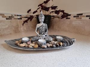 uma estátua de um Buda sentado numa mesa com legumes em Rinroe View in the Barony of Erris em Ballina