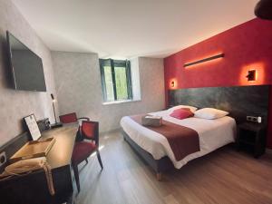um quarto de hotel com uma cama grande e uma secretária. em Logis Hostellerie la Chaumière em Arsonval