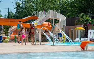 a group of children standing in front of a water park at Les sable du midi 3 in Valras-Plage