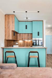 a kitchen with blue cabinets and two bar stools at Soho Magic Lux in Bar