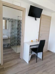 a desk and a chair in a room with a bathroom at I TRE CUORI in Taormina