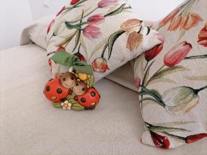 a bed with a pillow with two lady bugs on it at I TRE CUORI in Taormina