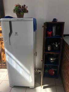 - un réfrigérateur blanc dans une cuisine à côté d'une étagère dans l'établissement Casa quadra praia Jacaraipe!, à Jacaraípe