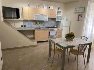 a kitchen with a table with chairs and a refrigerator at Balcone Eleonora in Cefalù