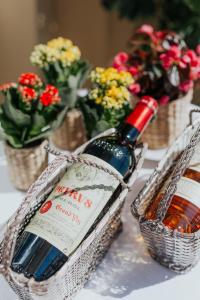 dos cestas con una botella de vino y flores en Hôtel Le Roquebrune en Roquebrune-Cap-Martin
