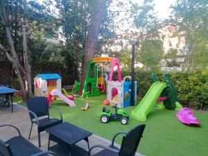 une aire de jeux avec des équipements de jeux sur une pelouse dans l'établissement Hotel Rita, à Cervia