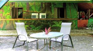 a table and two chairs and a table with a plant at Chosa Manglar Suites & Cabins in Puerto Jiménez