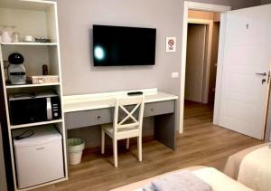 um quarto com uma secretária e uma televisão na parede em Room sweet Room 2 em Bolonha