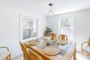 a dining room with a wooden table and chairs at Beach Bum Bungalow in Folly Beach