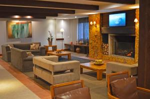 a living room with a couch and a fireplace at Sky Borges Hotel Alpenhaus - Gramado in Gramado