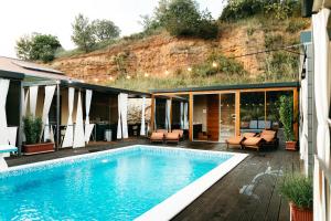 a house with a swimming pool with a hill behind it at Illyria Apartments in Skradin
