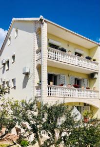 un edificio de apartamentos blanco con balcón en Villa Domora apartments, en Trogir
