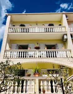 un edificio de apartamentos con balcones y macetas en Villa Domora apartments, en Trogir