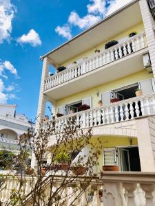 un edificio con balcones blancos y un cielo azul en Villa Domora apartments, en Trogir