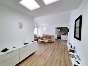 a white living room with a couch and a table at Luxury Coral Beach first line of the sea in Playa Honda