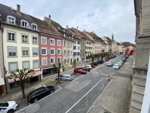 une rue de la ville avec des voitures garées dans la rue dans l'établissement Stay Swiss - 3 bedrooms Apartment in old town "Broadway" & " By the River", à Porrentruy