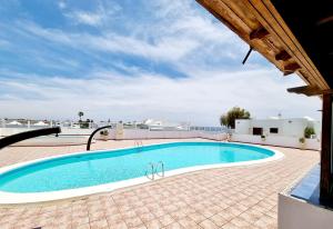 een groot zwembad in een bakstenen patio naast een gebouw bij Luxury Coral Beach first line of the sea in Playa Honda