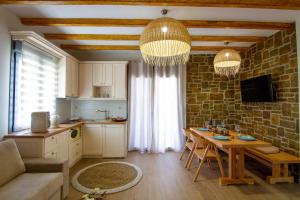 a living room with a table and a kitchen at Aphrodite Stone Apartments in Moúdhros