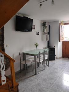 - une salle à manger avec une table, des chaises et une télévision dans l'établissement LA CASINA DEL CARRIL, à Colunga