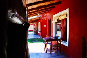 a red wall with a table and chairs in a room at La Aldea in San Rafael