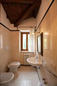 a bathroom with two sinks and a toilet and a window at Dimora BOUQUET & GOURMET in Ascoli Piceno