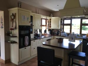 a kitchen with white cabinets and a black counter top at Annies Meadow. in Knock