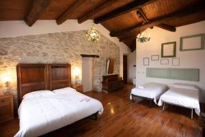 a bedroom with two beds and a stone wall at Dimora BOUQUET & GOURMET in Ascoli Piceno