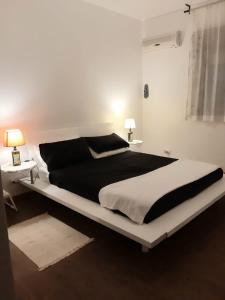 1 dormitorio con 1 cama grande, 2 mesas y 2 lámparas en Casavacanze Tuttapposto en Palermo