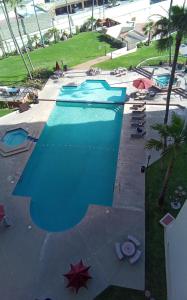 - une vue sur la piscine bordée de chaises et de parasols dans l'établissement Breathtaking Oceana Del Mar, à Rosarito
