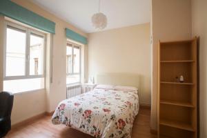 1 dormitorio con 1 cama con colcha de flores en Residencial Europa, en Salamanca