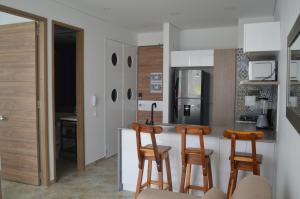 uma cozinha com um balcão e dois bancos em Apartasuite exclusivo VIP El Rodadero Santa Marta em Rodadero