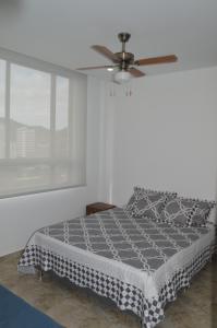 a bedroom with a bed with a ceiling fan at Apartasuite exclusivo VIP El Rodadero Santa Marta in Rodadero