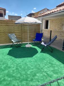 two chairs and an umbrella on a patio at The Best House in Bragança