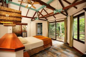 um quarto com uma cama, uma mesa e janelas em Villa Maya em Flores