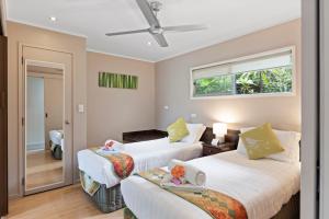 a bedroom with two beds and a window at Broad Leaf Villas in Burnt Pine