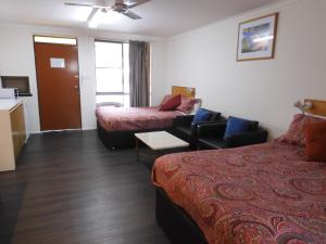 una camera d'albergo con due letti e un divano di Dalby Parkview Motel a Dalby