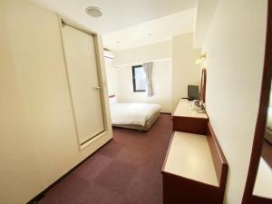 Asaka的住宿－Smile Hotel Kitaasaka，客房设有带一张床和镜子的卧室