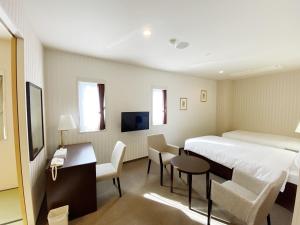 a hotel room with a bed and a table and chairs at Smile Hotel Kitaasaka in Asaka