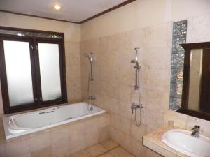 un bagno con vasca e lavandino di Dago Highland Resort a Bandung