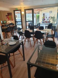 a restaurant with tables and chairs in a room at Fasthôtel Le Râle Des Genêts - Un hôtel FH Collection in Dun-sur-Meuse