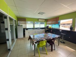 a kitchen with a table and chairs in a room at Mahana Lodge Hostel & Backpacker in Papeete