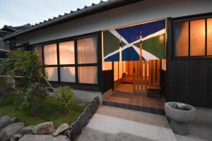 una casa con una bandera pintada a un lado. en Quaint House Naoshima, en Naoshima