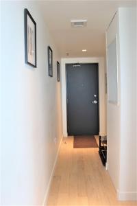 a hallway with a black door and a wooden floor at Luxury skyline condo in downtown FREE 24/7 parking in Winnipeg