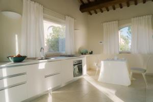 a kitchen with white cabinets and a table and chairs at Nontiscordardimé B&B Villa Agriturismo in Civitanova Marche