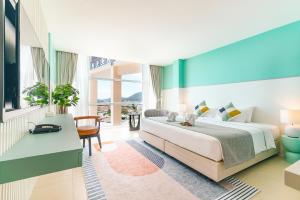 een hotelkamer met een groot bed en een bureau bij Hilltop Wellness Resort in Phuket