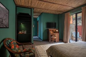 een slaapkamer met groene muren en een bed en een televisie bij Communal Hotel Telavi in Telavi